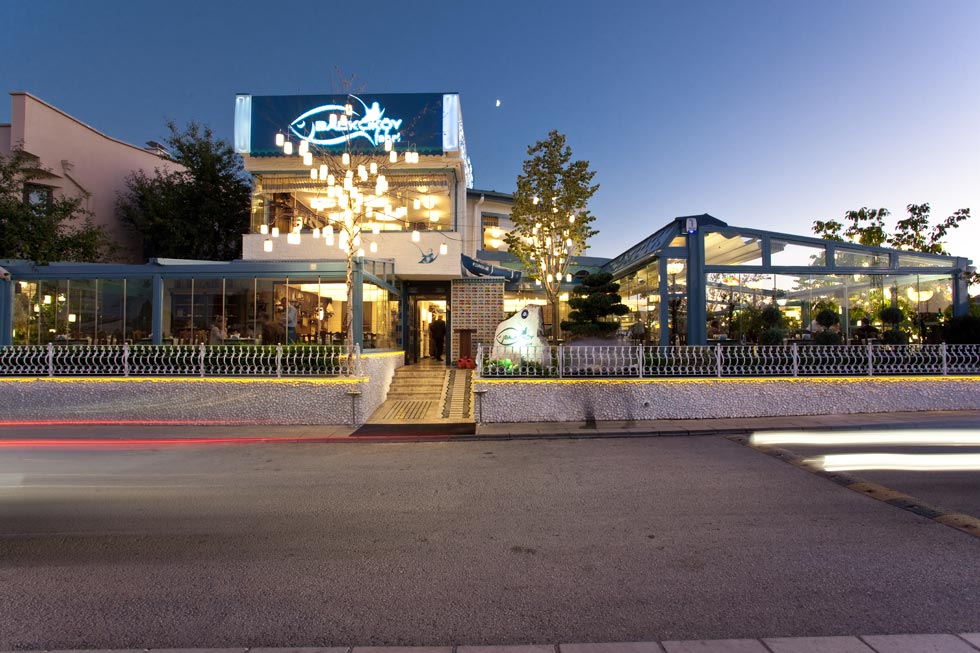 Balıkçıköy balık restoranı tasarımı: cephenin akşam görünümü ve ışıklı giriş
