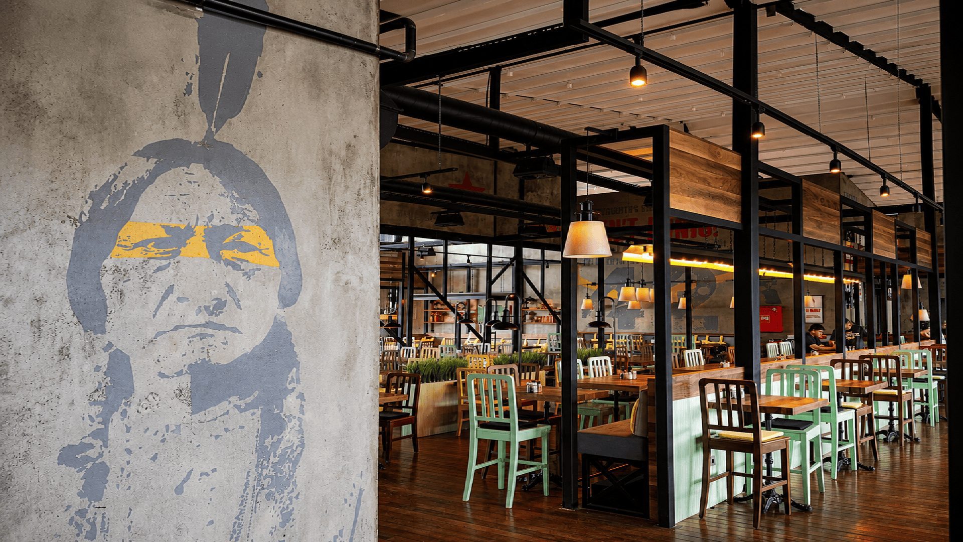6:45 Pub'da grafitili portre kolonu ve sarı sandalyeler