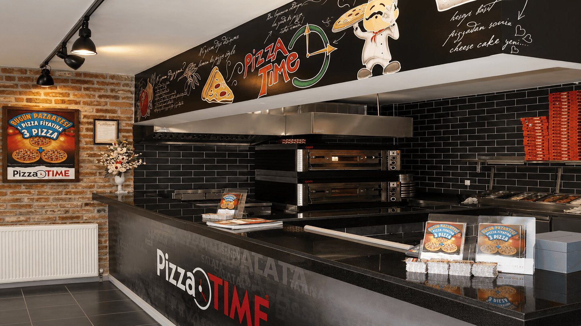 PizzaTime açık mutfağı, fırın ve siyah karolu tezgâh