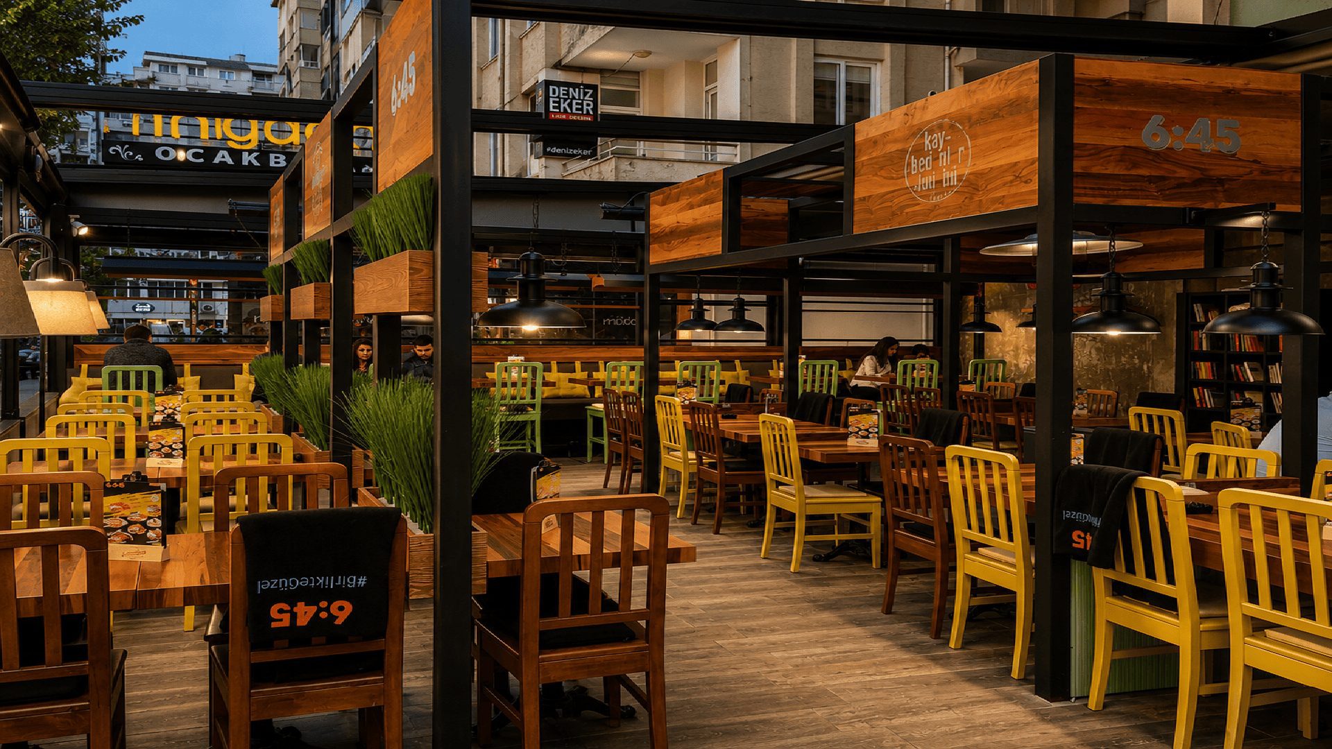 6:45 Pub'da siyah çelik çerçeve ve sarı sandalyeler