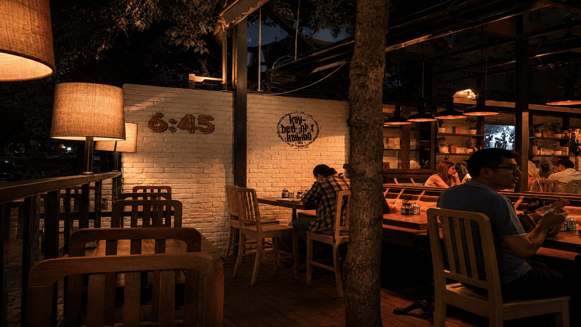 6:45 Pub'da 6:45 logolu beyaz duvar ve ağaç gövdesi