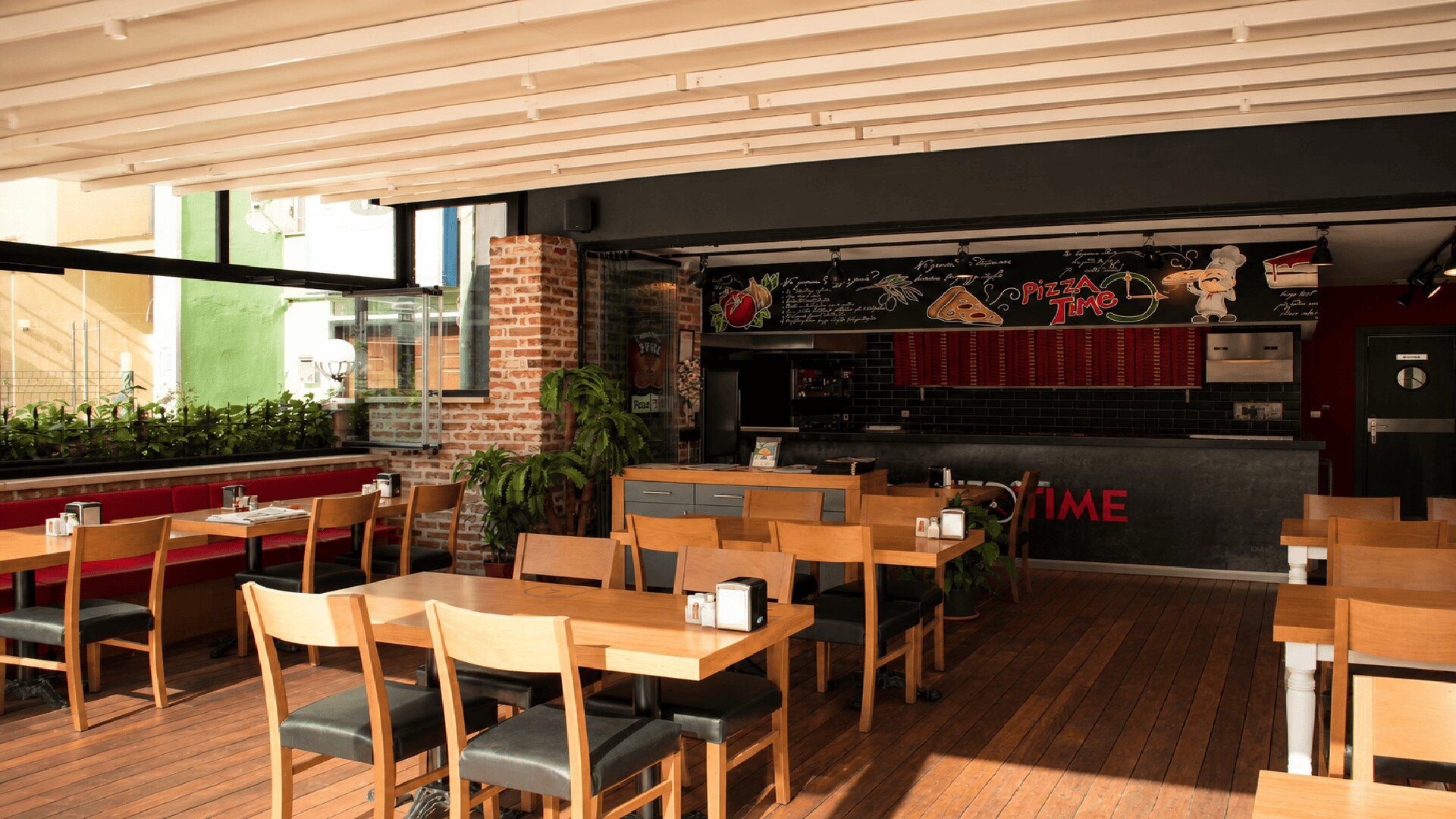 PizzaTime salonu, ahşap masalar ve sandalyeler